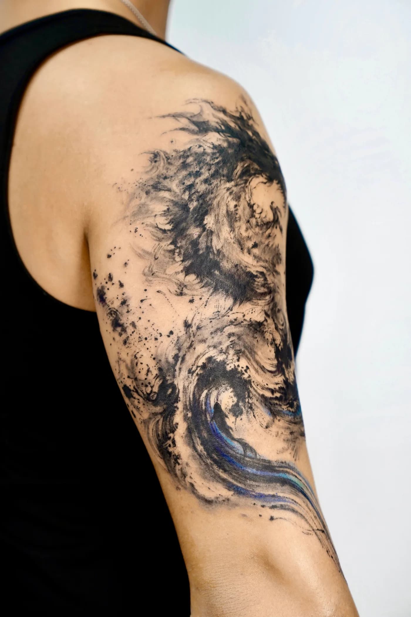 Rear angle of the dragon tattoo showing brush texture across the upper arm
