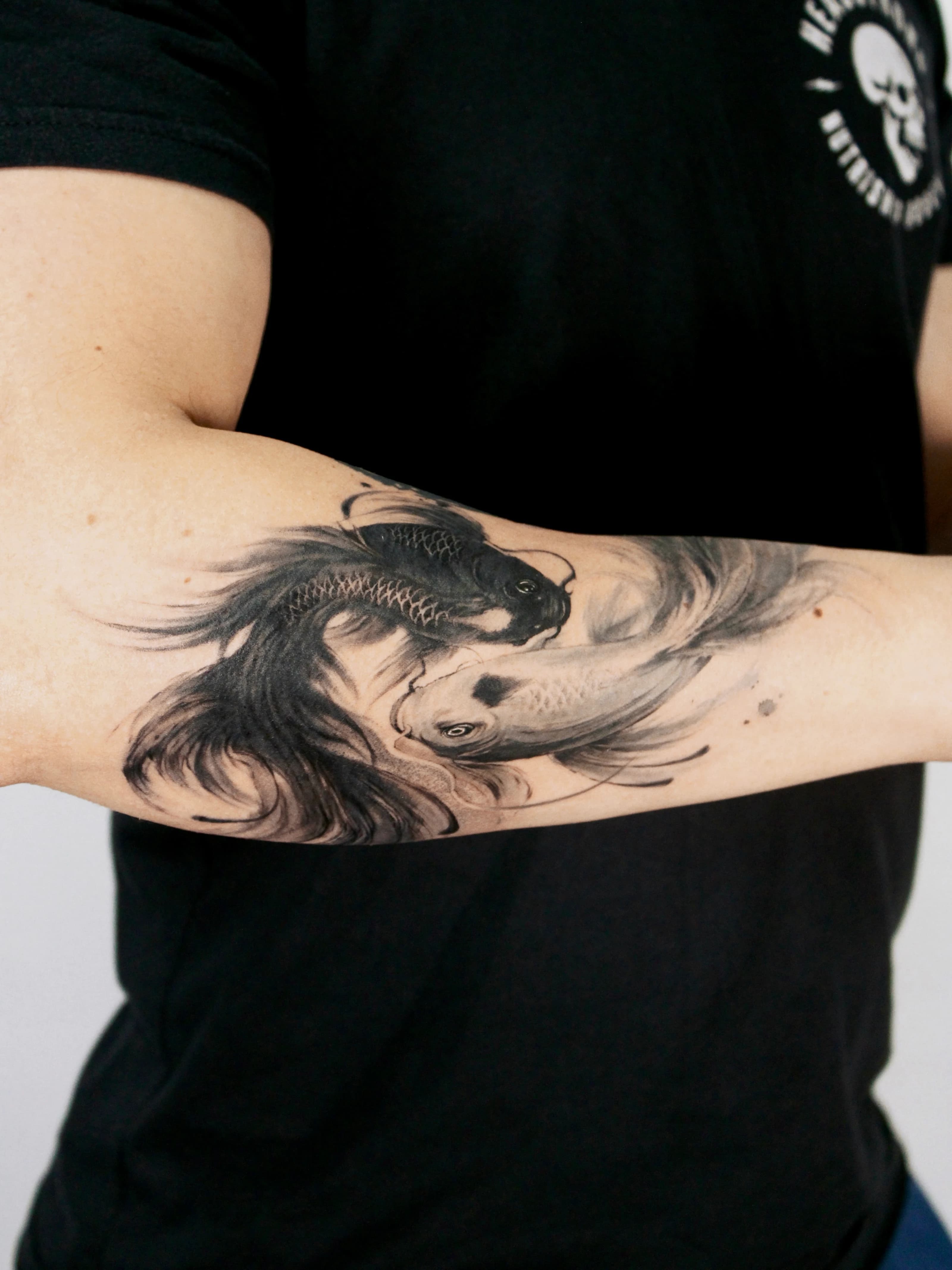 Detail angle of the yin-yang koi tattoo showing the flowing circular movement